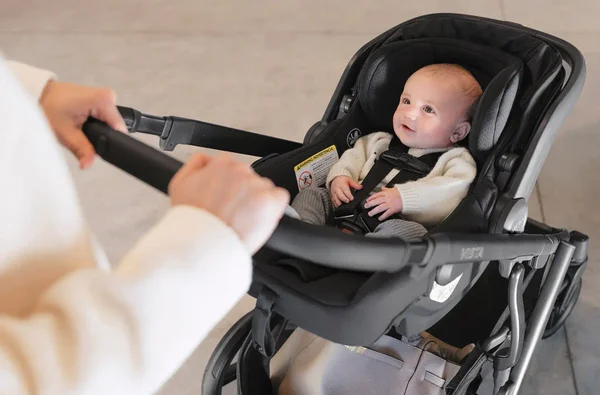 mother pushing baby in car seat travel system