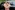 Smiling parent and child standing beside car