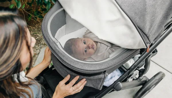 An infant looks through the ventilation window of the bassinet